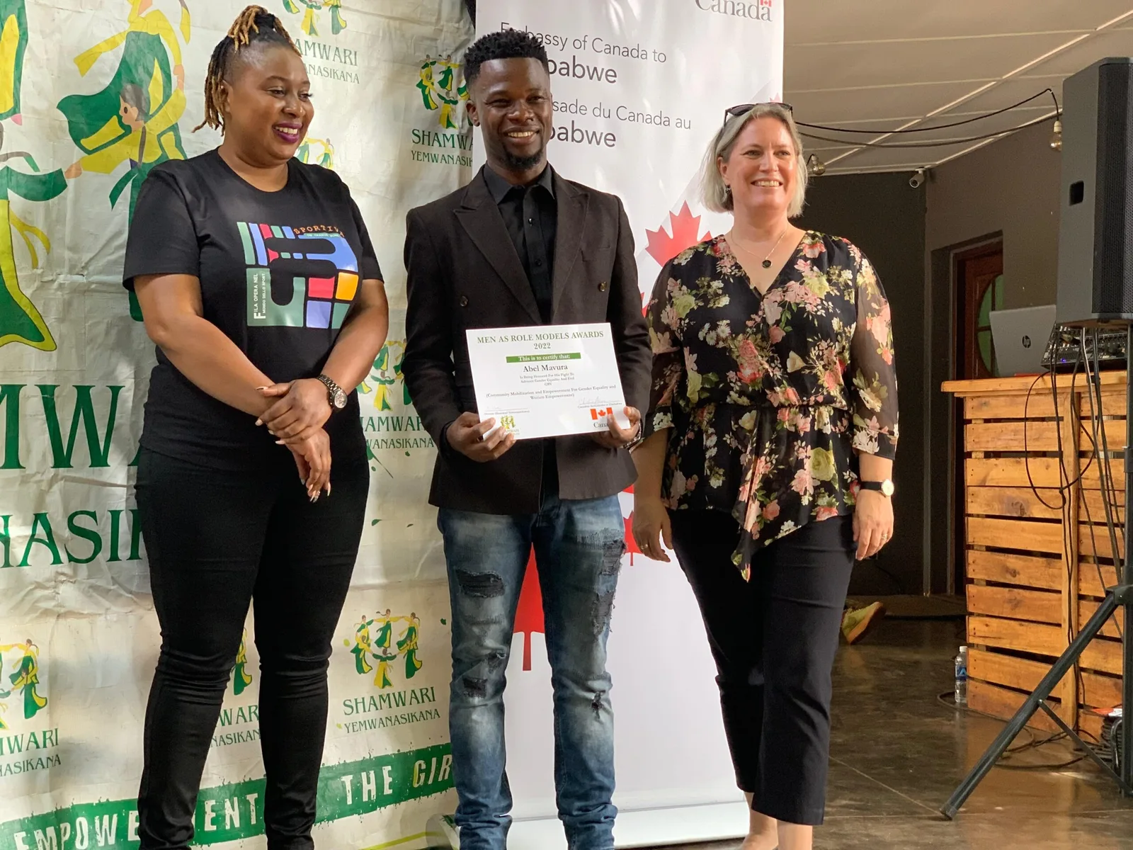 Abel Mavura receiving a certificate at a Shamwari YeMwanasikana and Embassy of Canada ceremony